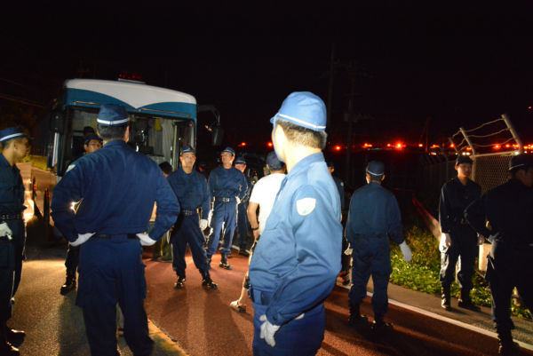 (はるか奥の赤い点滅灯が警察車両。車列は延々と続いていた。=3日午前4時57分、東村赤橋南詰 撮影:筆者=)